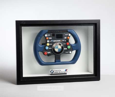 Framed replica BMW Williams F1 steering wheel,
 blue and black with coloured buttons, in a black box frame

 Please be aware all glass will be removed