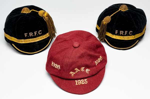 Three representative caps, circa 1920s,
 comprising red wool cap with cream initials A.A.C.C. and 1925-1926, bearing internal retail label for GULLAND