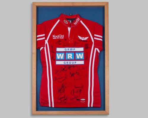 An autographed red and white Scarlets rugby union short-sleeved shirt display, 2005-06