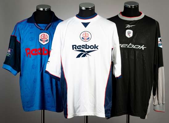 A group of three Bolton Wanderers match jerseys, 
 comprising Steve McAnespie white home no.24 premier league jersey; Andy Oakes black and grey no.13 