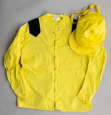 Sheikh Ahmed Al Maktoum racing silks,
 with maker's neck label for Gibson's Saddlers, Newmarket, yellow jacket with black epaulets, yellow cap, bears 