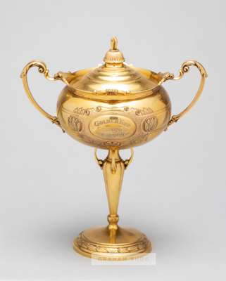 Gold horse racing trophy for the 1936 Chepstow Summer Cup,

a 9ct. gold twin handled cup and cover by Fattorini & Sons Ltd., Birmingham, 1936, on a sl
