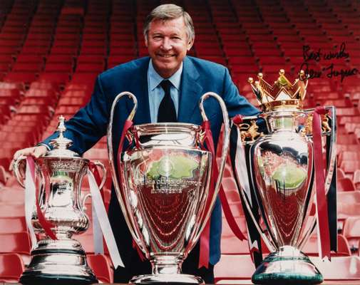 Manchester United "Treble" an autographed colour photograph of Sir Alex Ferguson, 
 with all three trophies, 22.5 by 26.5in. framed and glazed

All gl