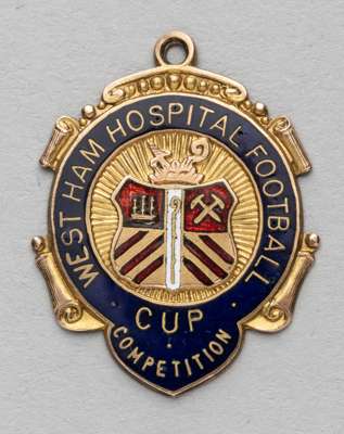 West Ham Hospital Football Cup competition medal awarded to referee J.R. Schumacher, 19th April 1913,
 obverse with enamelled shield crest and letteri