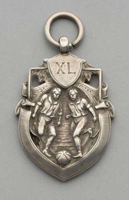 Silver football medal for Quella Trades, 1917,
 obverse embossed with two footballers and XL engraved in a shield, reverse engraved S.Sgt G Fisher Que