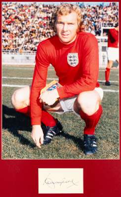 England's 1966 World Cup winning captain Bobby Moore signed photographic display,
 the photo featuring Bobby Moore in England kit, mounted above his a
