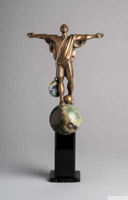 A trophy owned by Pelé featuring a bronze portrait of himself with arms outstretched 
 walking with a football across the surface of a marble globe, m
