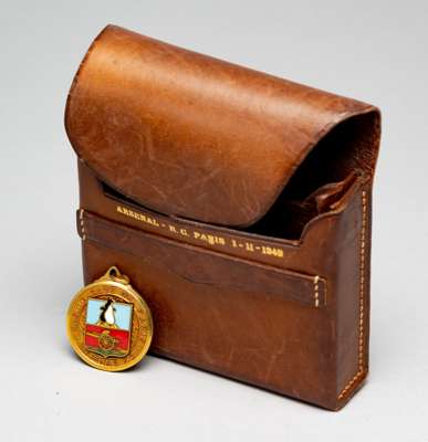 A leather Arsenal – RC Paris 1st November 1949 cigarette case, 
 brown leather with stitching and gilt lettering on the inner cover, 8 by 9 by 3cm.; s