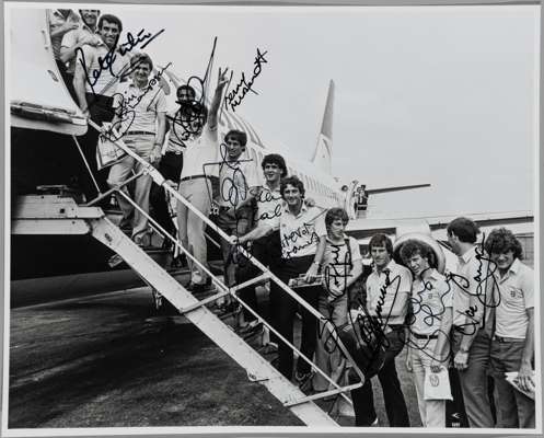 Signed b&w press photograph of the England team boarding the aeroplane at Luton airport for the FIFA World Cup in Spain, on 10th June 1982,
 featuring