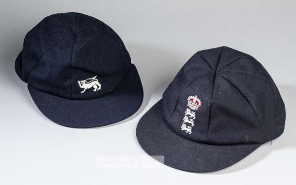 Two England caps for Test Match and ODI cricket,
 the first navy cap for a Home series, embroidered with three lions and crown emblem, interior bears 