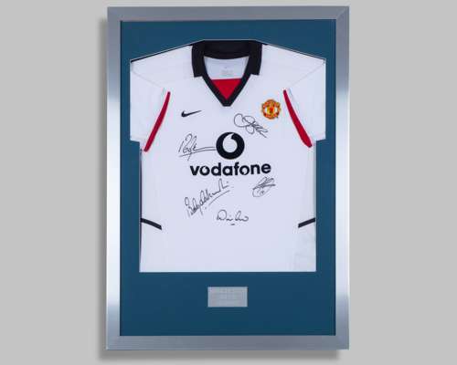 A white, black and red Manchester United autographed replica shirt display