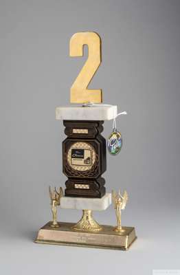 A brass and marble trophy with faux wooden column presented to Pelé by Radio Caracas Television
 an engraved metal plaque at the base reads "Dos de Or