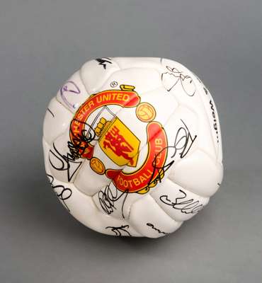 A Manchester United souvenir club football signed by the 1999 Treble Winning team, 20 signatures in black marker pen, Beckham, G Neviille, Solskjaer, 