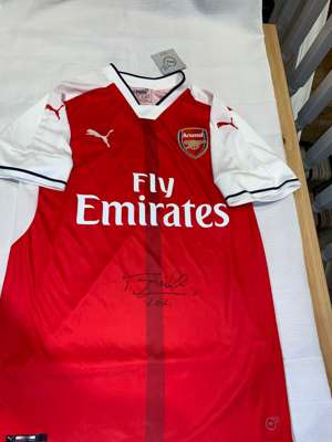 Terry Neill signed red and white Arsenal replica home jersey,
 Puma, short-sleeved with club crest and sponsor logo, signed in marker pen to front, wi