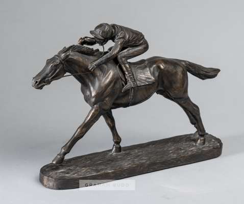 A bronze resin sculpture of a racehorse and jockey,
 depicting a realistic model of jockey on horseback raised upon a plinth base, bearing J SKEAPING,