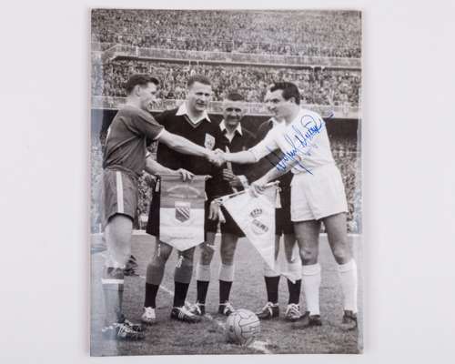 A black and white press photograph of Roger Byrne and Miguel Munoz exchanging pennants