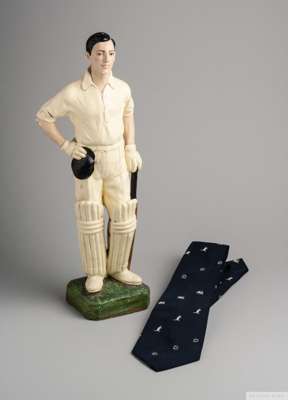 A 20th Century plaster painted cricket figure
 with pads, bat and cap, 46cm high, areas of chipping and some paint loss, and a 1877-1977 Ashes Centena