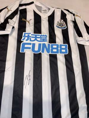 Jamaal Lascelles (captain) signed black and white Newcastle United replica home jersey 2018-19,
 Puma, short-sleeved with club crest and sponsor logo,