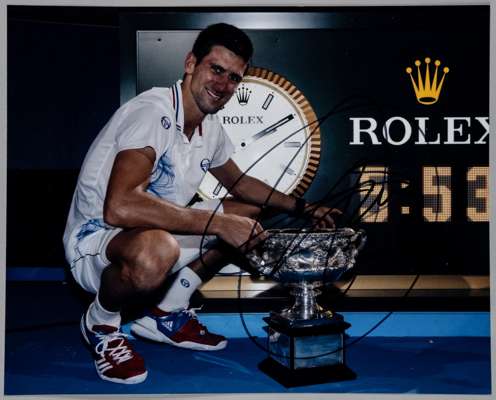 Novak Djokovic 21 Grand Slam tennis titles 2008-22 original colour 10 by 8in. photograph,
 depicting Djokovic posing with the Australian Open trophy w