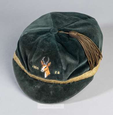 A green rugby representative cap
 bearing an embroidered springbok's head and dated 1924-28 on the front, with gilt tassel and braiding, the interior 