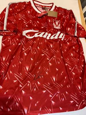 John Barnes signed red Liverpool retro jersey,
 short-sleeved with club crest and Candy sponsor logo, signed in marker pen on front, with retail tag a